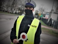 umundurowany policjant mikołowskiej drogówki stoi na drodze i trzyma tarczę do zatrzymywania pojazdów
