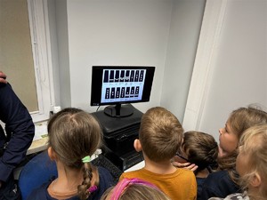 zgromadzenia wokół komputera uczniowie oglądają policyjne stopnie