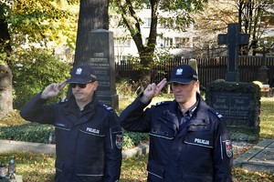 dwaj policjanci salutują przed grobem