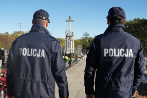 dwaj policjanci wchodzą na teren cmentarza w Ornontowicach