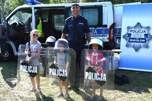 policjant oraz dzieci trzymające policyjne tarcze