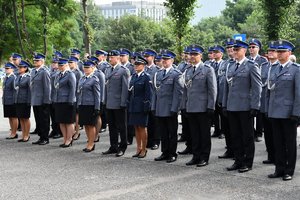 Umundurowani policjanci stoją szeregu przed komendą