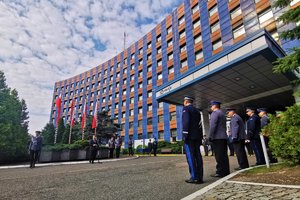 Zdjęcie kolorowe. Widoczni umundurowani policjanci biorący udział w uroczystości przed budynkiem komendy wojewódzkiej policji, w tym nadinsp. Roman Rabsztyn