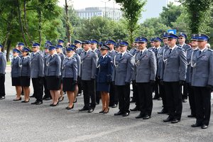 Zdjęcie kolorowe. Widoczni umundurowani policjanci biorący udział w uroczystości przed budynkiem komendy wojewódzkiej policji