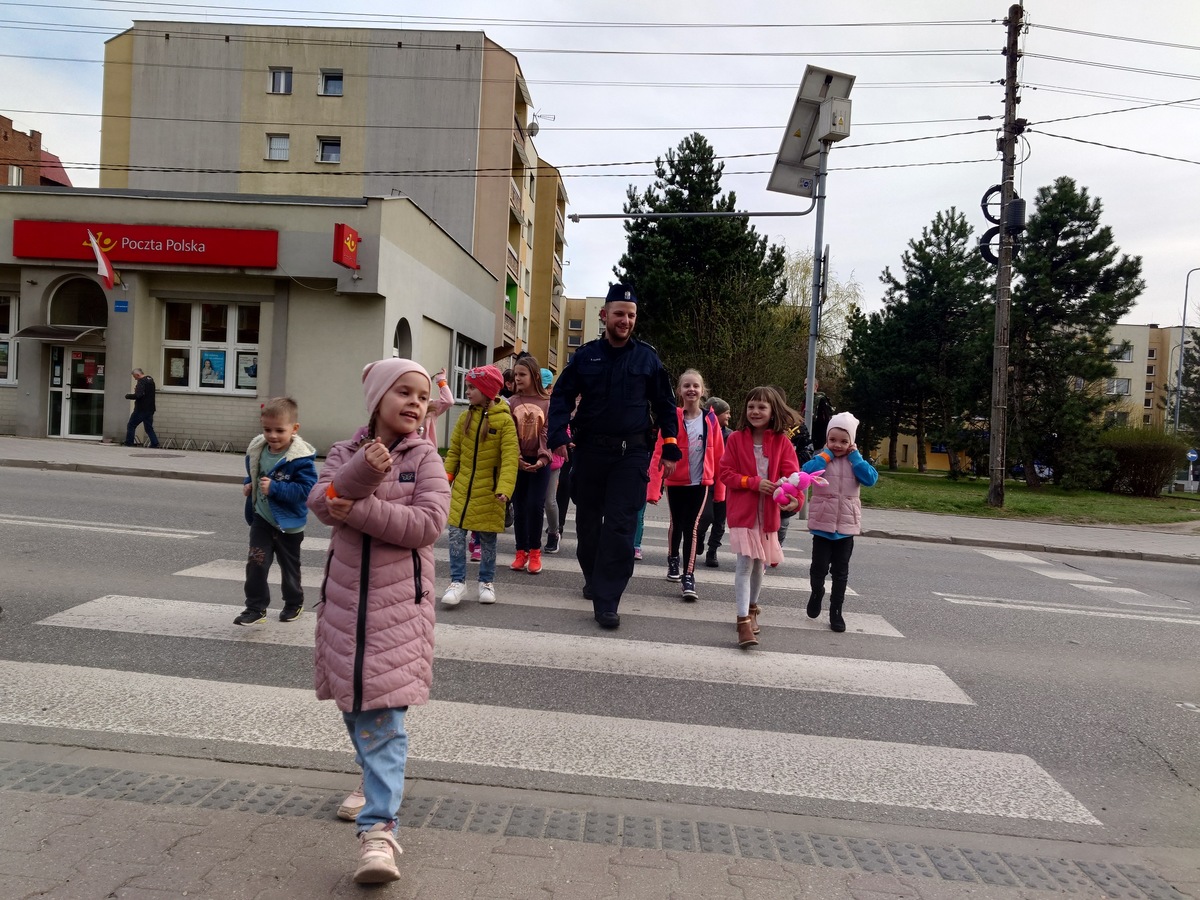 dzielnicowy przeprowadza dzieci przez ozakowane przejście, centrum Łazisk Górnych