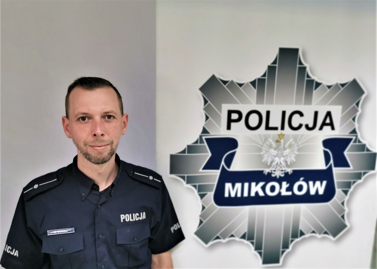 policjant na tle logo mikołowskiej komendy