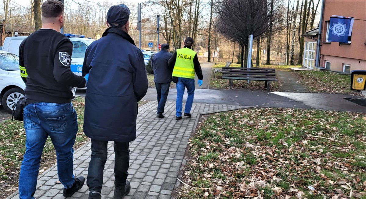 na zdjęciu widać dwóch policjantów, którzy prowadzą dwóch zatrzymanych mężczyzn