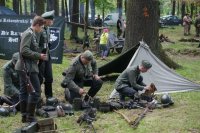 zdjęcie przedstawia grupę pięciu żołnierzy przygotowujących swoje wyposażenie