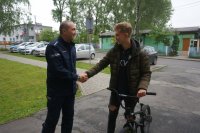 Komendant Powiatowy Policji w Mikołowie, ściska dłoń właścicielowi roweru- 15 letniemu Piotrkowi