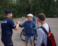 Policjant wita się z dziećmi podczas spotkania &amp;quot;Łaziskie rolkowanie&amp;quot;