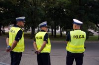 Na fotografii widać trzech umundurowanych policjantów ruchu drogowego na trasie odcinka specjalnego