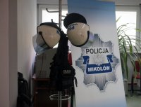 Logo mikołowskiej komendy oraz wyposażenie policjantów do zabezpieczania imprez masowych