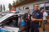 Na fotografii widać policjantów: asp. Paweł Oleksiński ( w ubraniu cywilnym) oraz sierż.szt. Artur Ceran, na tle radiowozu