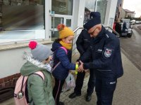 na zdjęciu: policjanci wręczają odblask dzieciom, Łaziska Górne