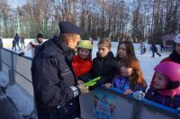 na zdjęciu: polcjant rozdaje odblaski