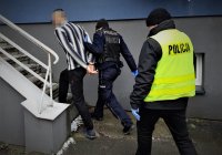 na zdjęciu: policjanci z zatrzymanym mężczyzną wchodzą do komisariatu