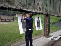 na zdjęciu: policjant ruchu drogowego przypina tarczę do strzelania