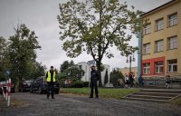 na zdjęciu: policjanci prewencji stoją na parkingu przed szkołą podstawową