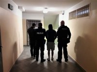 na zdjęciu widać zatrzymanych przez policjantów mężczyzn w trakcie doprowadzenia do jednostki Policji