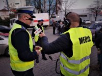 reporter radia przeprowadza wywiad z policjantem ruchu drogowego. Sytuacja odbywa się w centrum Mikołowa w ramach akcji &quot;Świeć przykładem&quot;