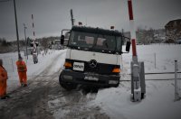 na zdjęciu widać samochód ciężarowy na przejeździe kolejowym, wokół pełno śniegu