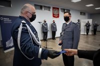 Komendant Wojewódzki Policji w Katowicach wręcza odznakę Komendantowi Powiatowemu Policji w Mikołowie, w tle inni policjanci