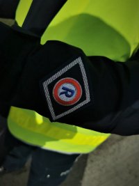 na zdjęciu: naszywka ze znakiem ruchu drogowego na policyjnej kurtce