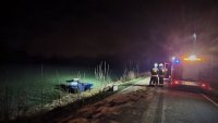 na zdjęciu widać wóz straży pożarnej. Obok, w polu, wrak samochodu osbowego po wypadku.