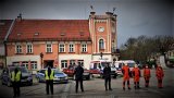 mikołowski rynek, na którym stoją przedstawiciele służb mundurowych oraz ratownicy medyczni. W tle ich samochody