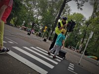 policjant pokazuje dzieciom jak prawidłowo przejść przez pasy
