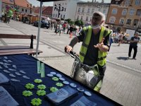 mężczyzna stoi przy stanowiku profilaktycznym Policji. Na stole rozłożone są odblaskowe elementy