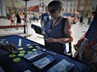 starsza kobieta stoi przy stoisku Policji, ogląda ulotki