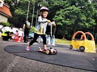 mała dziewczynka jeździ na hulajnodze na placu Miasteczka Ruchu Drogowego