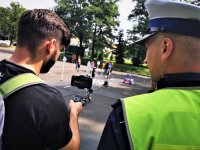 policjant drogówki rozmawia z mężczyzną, obaj patrzą w ekran telefonu