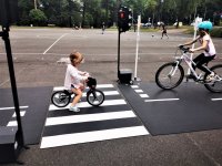 dziewczynka jadąca na rowerze po trasie miasteczka ruchu drogowego