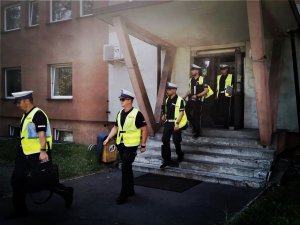 policjanci ruchu drogowego, ubrani w odblaskowe kamizelki, wychodzą z budynku komendy