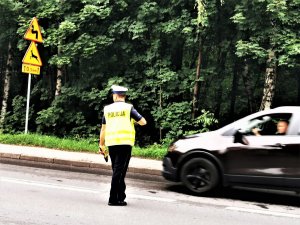 policjant drogówki stoi na drodze i kontroluje samochody, Łaziska Górne, ulica świętej Barbary