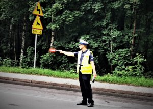 policjant drogówki stoi na drodze i kontroluje samochody, Łaziska Górne, ulica świętej Barbary