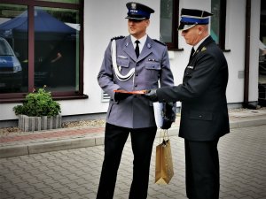 Zastępca Komendnata Powiatowego Policji w Mikołowie w towarzystwie Komendanta Państwowej Straży Pożarnej w Mikołowie. Oboje w mundurach galowych, w tle budynek szpitala