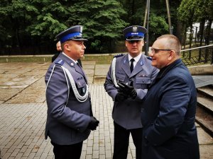 dwóch umundurowanych policjantów rozmawia ze starszym mężczyzą