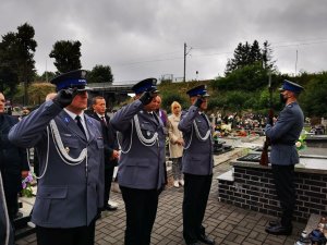 trzech umundurowanych policjantów oddaje hołd poległym mundurowym. Scena ma miejsce na cmentarzu w Ornontowicach