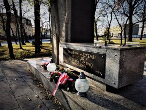 płyta przy pomniku Ofiar Faszyzmu w Mikołowie, przed płytą leżą wieńce oraz stoją znicze