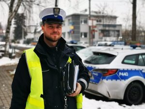 starszy sierżant Radosław Szpiech, , policjant drogówki, w tle radiowozy