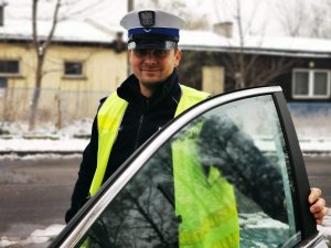 stojący przy radiowozie policjant drogówki