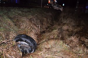 leżące w rowie koło samochodu, dalej rozbite auto