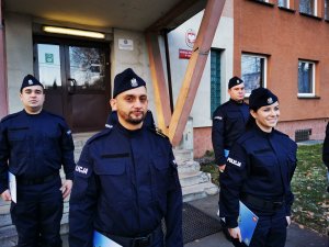 stojący przed budynkiem mikołowskiej komendy nowo przyjęci policjanci, zbliżenie na czworo z nich, nie mają założonych na twarzach maseczek