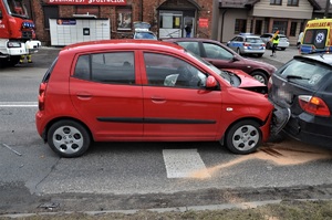 dwa uszkodzone w czasie zderzenia samochody, w kolorze czerwonym i czarnym