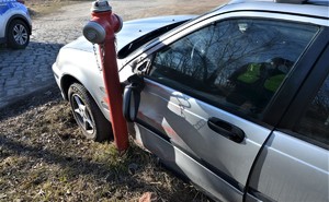 samochód osobowy marki honda po kolizji z czerwonym hydrantem