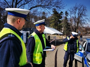 policjanci drogówki tuż przed rozpoczęciem biegu w centru miasta. Jeden z nich rozmawia przez telefon