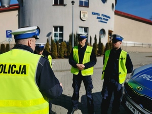 policjanci drogówki stoją przed budynkiem aquaparku i słuchają swojego naczelnika